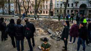 Люди у воронки от ракеты в парке в центре Киева                                                        