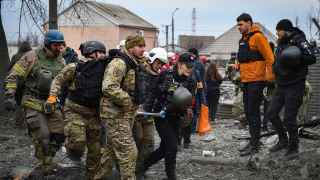 Спасатели выносят раненых после российской атаки в Запорожье