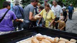 Местные жители стоят в очереди за хлебом. 
