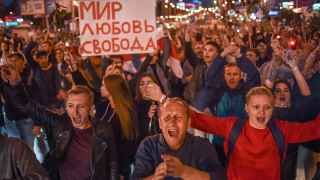 Толпы людей стояли на центральных улицах Минска, размахивая зажженными телефонами и цветами, и аплодировали, когда проезжавшие машины гудели им в знак поддержки.