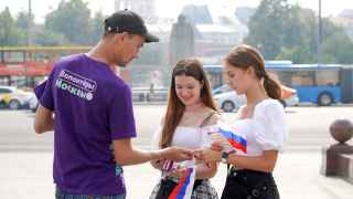 Раздача праздничной символики ко Дню флага России в центре Москвы.