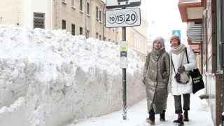 Женщины проходят мимо сугробов на Большой Никитской улице в центре Москвы. 
