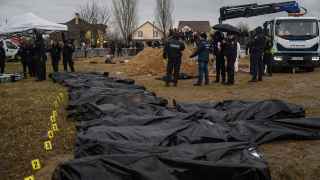 Украина. Буча. Работники кладбища и сотрудники полиции возле тел, извлеченных из массового захоронения.