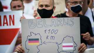 Протестующий держит в руках картонку с изображением границ Германии и Беларуси во время демонстрации против результатов выборов и продолжающегося насилия после белорусских президентских выборов на Потсдамской площади в Берлине.