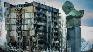Памятник украинскому поэту Тарасу Шевченко на фоне разрушенного в результате артобстрелов жилого дома, Бородянка, Киевская область.