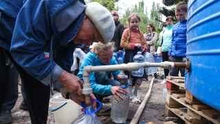 Жители Мариуполя набирают воду.