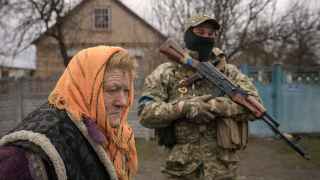 Женщина ждет раздачи продовольствия в селе Мотыжин, которое до недавнего времени находилось под контролем российских военных.